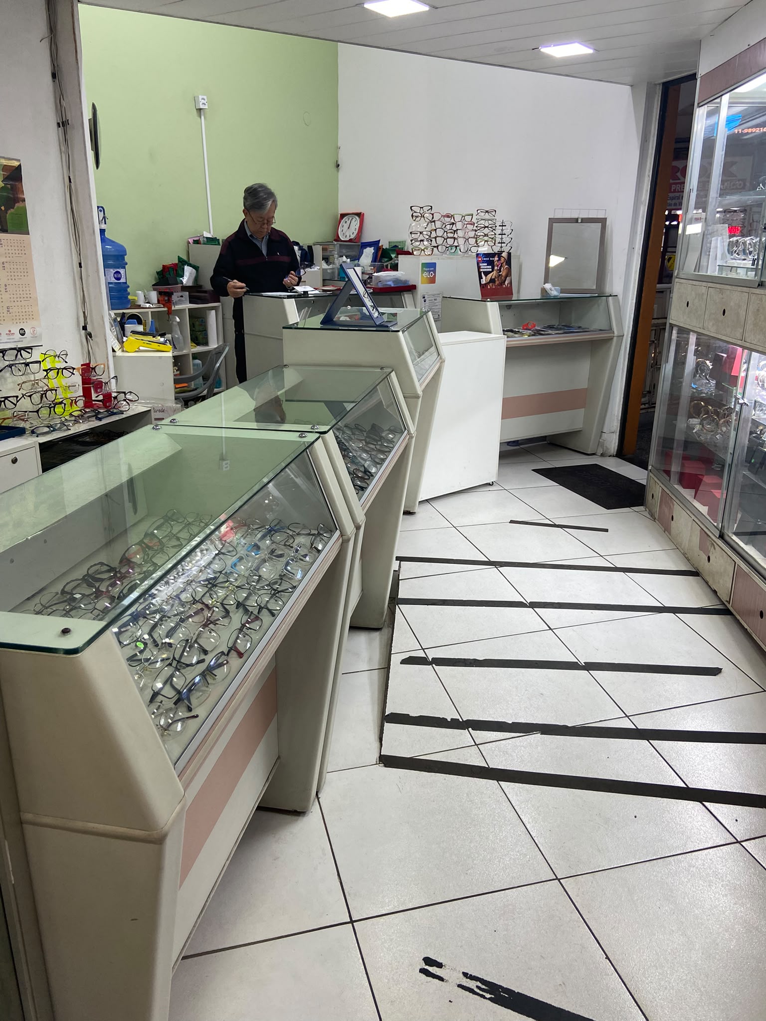 Proprietário atendendo no balcão da ótica